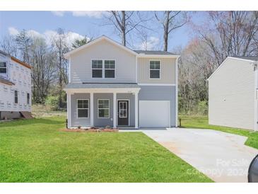 Two-story house with gray and beige siding, a grassy lawn, and a driveway at 235 Long St, Statesville, NC 28677