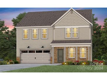 Two-story house with beige siding, stone accents, and a two-car garage at 13728 Roderick Dr # 169, Huntersville, NC 28078