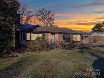 Brick ranch house with landscaped yard, at dusk at 904 S Main St, Landis, NC 28088