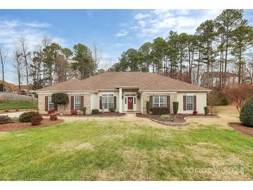 Brick ranch home with landscaped yard and red door at 5361 Harvest Hill Dr, Harrisburg, NC 28075