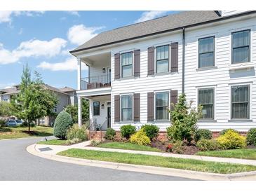 Two-story home with white siding, brown shutters, and a landscaped front yard at 122 Mint Ave # D, Mooresville, NC 28117