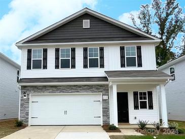 Charming two-story home with a dark gray and white exterior, stone accents, and a white garage door at 7313 Greenrock Ct, Charlotte, NC 28215