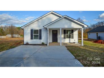 Charming white house with a front porch and driveway at 418 Lytton St, Troutman, NC 28166