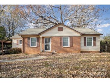 Brick ranch home with brown shutters, and a spacious yard at 6619 The Plz, Charlotte, NC 28215