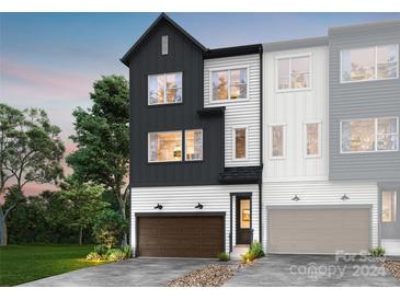 Modern two-story townhome with dark gray and white exterior, two-car garage, and landscaping at 8016 Cedarsmith Ct, Charlotte, NC 28217