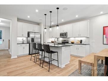 Modern kitchen with stainless steel appliances and island at 8022 Franklin Trail St, Mint Hill, NC 28227