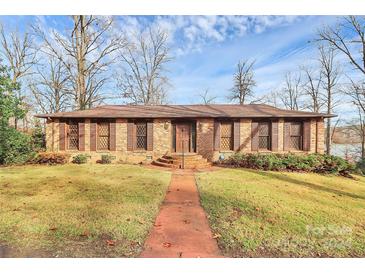 Brick ranch house with brown shutters, a paved walkway, and a well-maintained lawn at 117 Channel Ln, Belmont, NC 28212