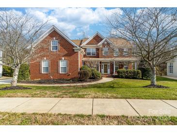 Brick two-story home with landscaped lawn and walkway at 1311 Aringill Ln, Matthews, NC 28104