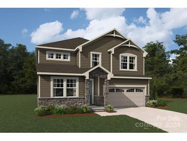 Two-story house with brown siding, stone accents, and a two-car garage at 1432 Mccollum N St, Monroe, NC 28112