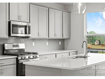 Modern kitchen with stainless steel appliances and white quartz countertops at 1750 Blanche St, Charlotte, NC 28262