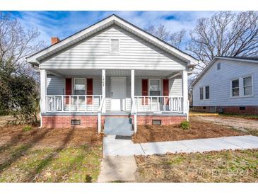 Charming gray house with a front porch, red shutters, and a well-maintained lawn at 1909 Glenwood St, Kannapolis, NC 28083