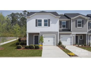 Two-story townhome with gray and white siding and a two-car garage at 2023 Old Rivers Rd, Concord, NC 28027