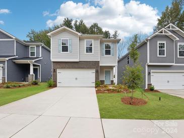 Two-story home with brick and siding, two-car garage, and landscaped lawn at 4024 Bufflehead Dr, Charlotte, NC 28269