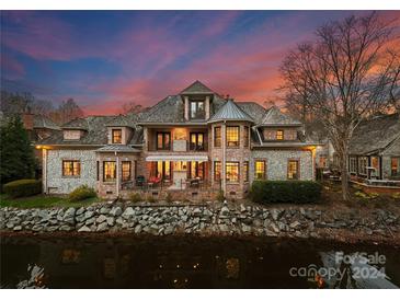 Luxury brick home with stone accents, situated on waterfront lot. Features a large patio and stunning sunset view at 2310 La Maison Dr, Charlotte, NC 28226