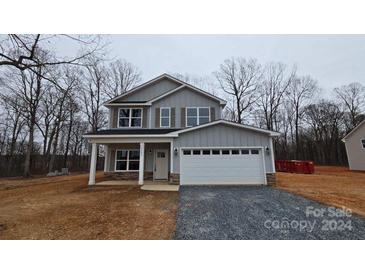 Two-story house with gray siding, white garage door, and stone accents at 2609 Plyler Mill Rd, Monroe, NC 28112