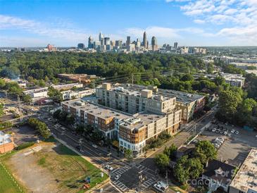 Aerial view of a modern apartment building with city skyline in the background at 1315 East Blvd # 433, Charlotte, NC 28203