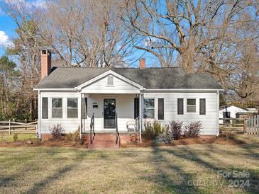 Charming white house with brick steps, front porch, and well-manicured lawn at 8532 Old Plank Rd, Charlotte, NC 28216