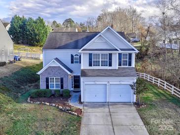 Two-story house with a brick and siding exterior, two-car garage, and landscaping at 3380 Merchant Ln, Davidson, NC 28036