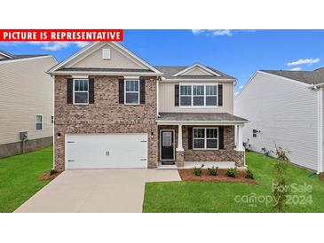 Two-story brick home with a white garage door and landscaped lawn at 197 Giant Oak Ave, Statesville, NC 28677