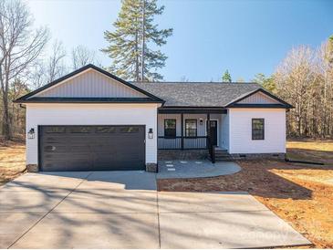 Newly constructed home with white siding, dark gray garage door, and a covered front porch at 2462 Shoal Rd # 11, Crouse, NC 28033