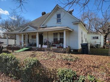 Two-story house featuring a wraparound porch and mature trees at 1002 N Hayne St, Monroe, NC 28112