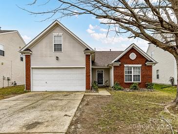 Brick ranch house with attached garage and a well-maintained lawn at 7120 Winding Cedar Trl, Harrisburg, NC 28075