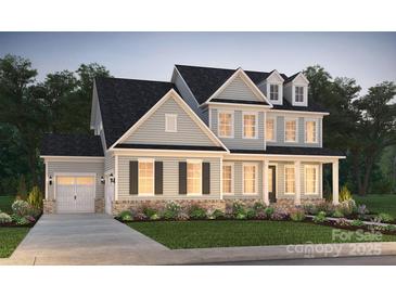 Two-story house with gray siding, brick accents, and a two-car garage at 14109 White Gardens Ln # 6, Huntersville, NC 28078