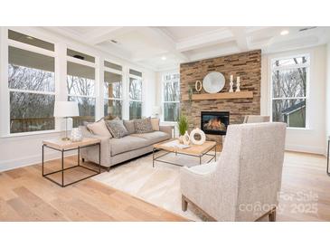 Bright living room features a stone fireplace, hardwood floors, and ample natural light at 131 High Lake Dr, Statesville, NC 28677