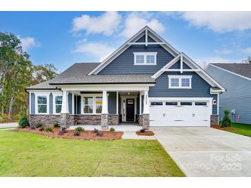 Two-story house with gray siding, stone accents, and a two-car garage at 3006 Cedar Falls Dr # 12, Waxhaw, NC 28173