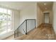 Modern staircase with metal railing and hardwood floors, overlooking a scenic view at 8010 Litaker Manor Ct, Charlotte, NC 28270