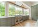 Kitchen features stainless steel range, custom cabinetry, and expansive windows with wooded views at 8010 Litaker Manor Ct, Charlotte, NC 28270