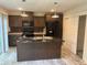 Kitchen with dark cabinets, granite counters, and island at 5756 Dalmatian St, Iron Station, NC 28080