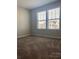 Bright bedroom with neutral walls, carpet, and two windows at 527 Smokehouse Ln, Albemarle, NC 28001