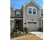 Tan two-story townhome with a two-car garage and landscaping at 12027 Gambrell Dr # 0054, Charlotte, NC 28278