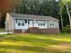 Brick and beige single-story home with a landscaped yard and trees at 5716 Dalmatian St, Iron Station, NC 28080