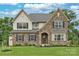 Two-story home with stone and beige siding, black shutters, and a two-car garage at 11330 James Coy Rd # Covington, Davidson, NC 28036