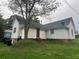 White sided home with brick foundation, a red door, and a large tree at 418 Hill St, Monroe, NC 28110