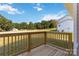 Wooden deck overlooking a grassy backyard with trees and other houses in the distance at 1030 Heath Helms Rd, Monroe, NC 28110