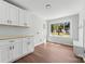 Bright laundry room with white cabinets and built-in bench at 506 E Maine Ave, Bessemer City, NC 28016