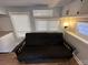 Relaxing living room with a comfortable futon and large window at 112 Sycamore St, New London, NC 28127