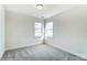 Well-lit bedroom with gray carpeting and two windows at 8631 Frank Grier Rd # 6, Charlotte, NC 28215