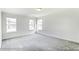Well-lit bedroom with grey carpet and multiple windows at 8631 Frank Grier Rd # 6, Charlotte, NC 28215