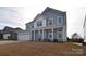 Two-story house with gray siding, white columns, and a two-car garage at 105 Megby Trl, Statesville, NC 28677