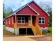 Charming red house with a wooden porch and stairs at 208 Nottingham Dr, York, SC 29745