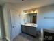 Double vanity bathroom with gray cabinets and a large mirror at 125 High Rock Ct # 07, Statesville, NC 28677