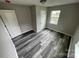 Simple bedroom with grey vinyl flooring, white doors, and a window at 108 Lee Dr, Shelby, NC 28150