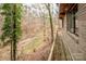 Elevated deck overlooks wooded backyard with a stream at 156 Beaten Path Rd, Mooresville, NC 28117