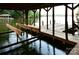 Covered boat lift with wooden dock and lake views at 165 Clearview Point Dr, Mount Gilead, NC 27306