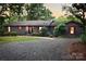 Gray exterior home with red accents, a gravel driveway, and landscaping at 165 Clearview Point Dr, Mount Gilead, NC 27306