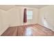 Simple bedroom with hardwood floors and a window with maroon curtains at 712 Tennyson Dr, Charlotte, NC 28208